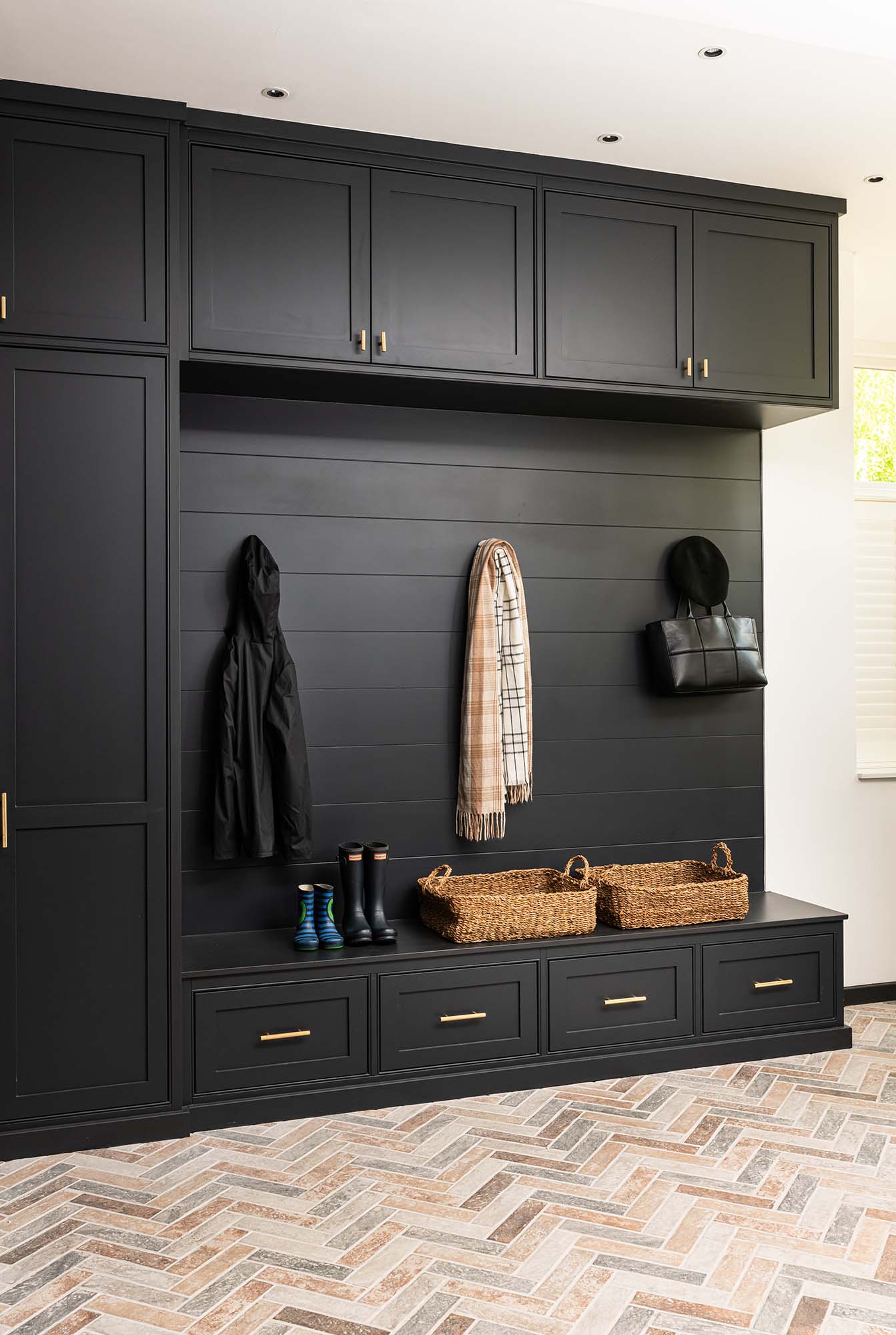 boot room with black units and wellies
